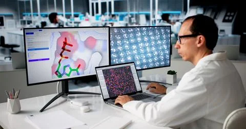 Scientist Studies Protein Data On Computer For New Drug Development. Foto stock