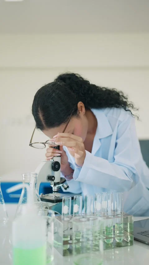 Scientist studies samples with microscope and laptop 库存影片 343511292