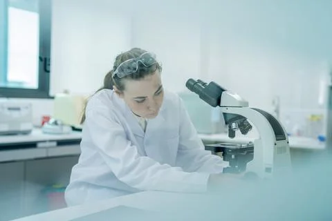 Scientist studies samples with a microscope in a laboratory setting during .. Stock Photos