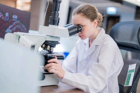 Scientist studies samples using a microscope in a laboratory setting during.. Stock Photos
