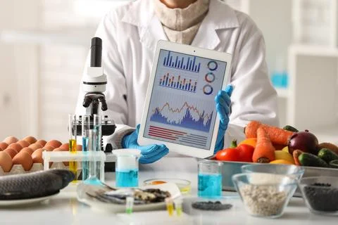 Scientist with tablet computer and products for testing in laboratory. HACCP  Stock Photos