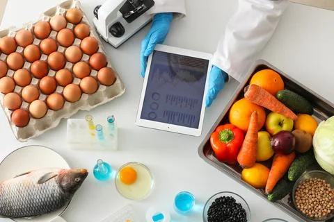 Scientist with tablet computer and products for testing in laboratory. HACCP  Stock Photos