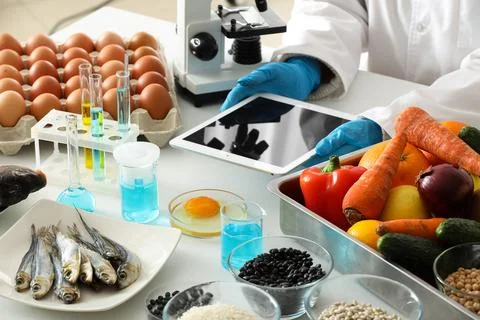 Scientist with tablet computer and products for testing in laboratory. HACCP  Stock Photos