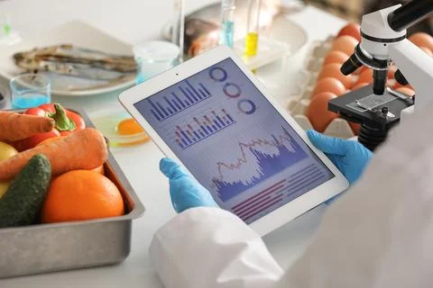Scientist with tablet computer and products for testing in laboratory. HACCP  Stock Photos