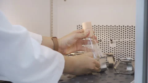 Scientist take the tube with yellow solution out of Orbital Shaker 50fps Stock-Footage 247403953