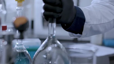 Scientist takes water sample from flask and places it in a sample tray Stock Footage 92501712