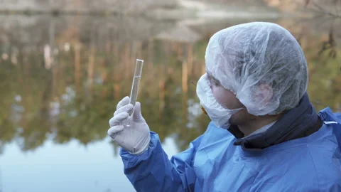 A scientist takes a water sample from a river. Stock Footage 157320041
