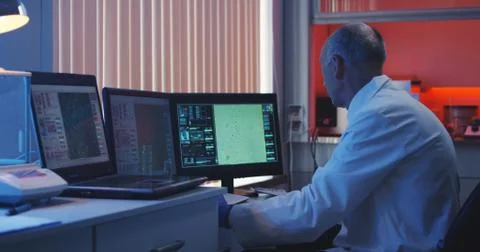 Scientist taking notes at computer screen 스톡 사진