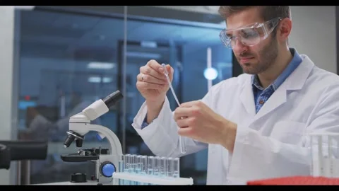 Scientist taking samples from tubes in the laboratory, uses Petri dish. Doctor Stock Footage 144502716