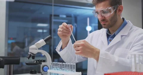 Scientist taking samples from tubes in the laboratory, uses Petri dish. Doctor Stock Footage 144639941