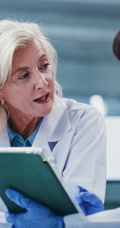 Scientist, team and discussion with tablet at laboratory with talk, feedback and Stock Footage 331517864