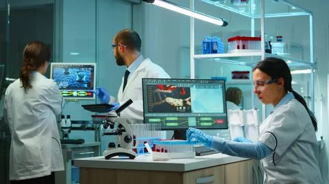 Scientist team checking virus development using high tech Stock Photos