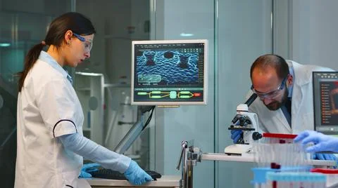 Scientist team checking virus development using microscope Stock Photos