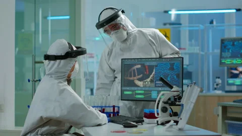 Scientist team in prorection suit arguing in front of pc looking at virus Stock Footage 147734743