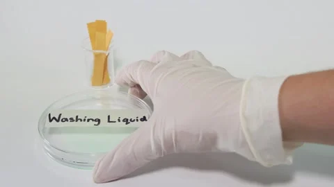 Scientist testing ph level of washing liquid using universal indicator stri.. Stock Footage 332628348