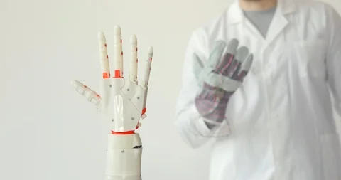Scientist is testing robotic prosthesis hand which repeats the movement of his Stock Footage 106220932