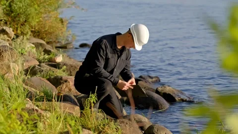 Scientist Testing Water for Pollution on Rocks in Outdoor Environmental Study Stock Footage 323069824