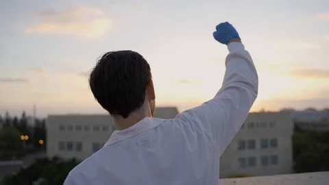 Scientist throws his hand up in enthusiasm and success with sunrise in BG Stock Footage 112631532