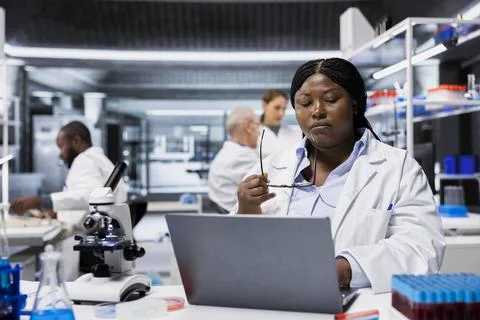Scientist typing experiment results data into laptop software in laboratory Stock Photos