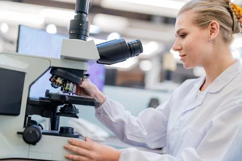 Scientist uses microscope to examine samples in laboratory setting during d.. Stock Photos