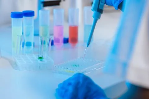 Scientist using digital pipette for measuring liquids, dripping fluid to test Foto stock