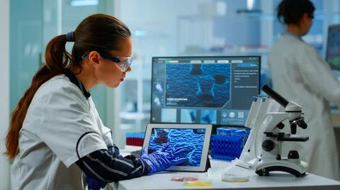 Scientist using digital tablet analysing virus evolution Stock Photos