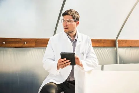 Scientist using digital tablet in plant growth research centre poly tunnel Stock Photos