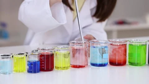 Scientist Using Glass Pipette to Mix Colorful Liquids in Laboratory Beakers Stock Footage 340254047