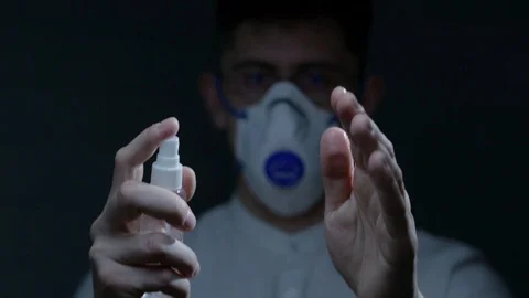 Scientist using hand sanitizer alcohol spray Stock Footage 126357178