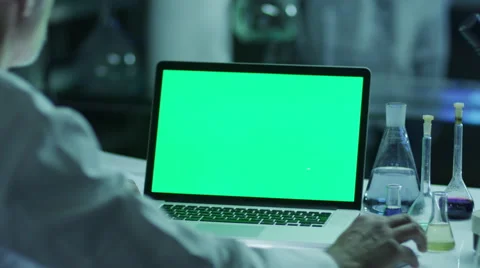 Scientist is using Laptop with Green Screen in Laboratory. Great for Mock-up. Stock Footage 48421426