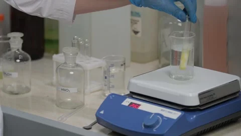 Scientist Using Magnetic Stirrer for Chemical Experiment Stock Footage 306319341