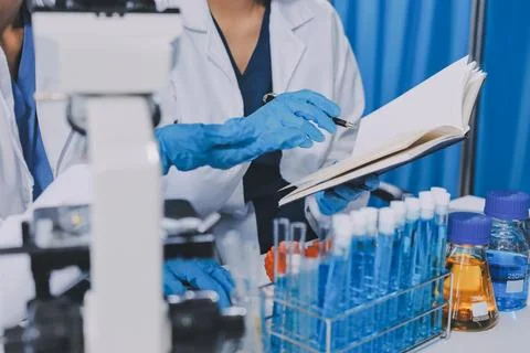 Scientist using microscope in laboratory. Close-up of a researcher's hands .. Stock Photos