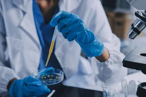 Scientist using microscope in laboratory. Close-up of a researcher's hands .. Stock Photos