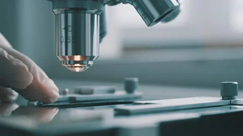 Scientist using a microscope in laboratory Stock Footage