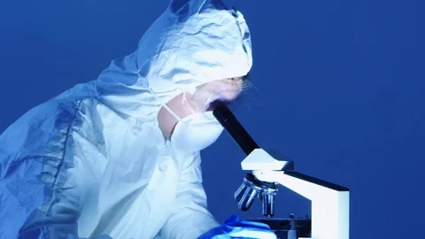 Scientist using microscope with protective suit Stock Footage 80131762