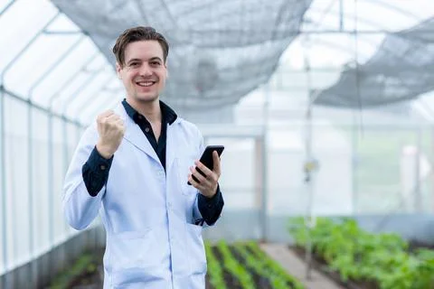 Scientist using Smart Phone. Scientist work at Vegetable Garden Lab site Stock Photos
