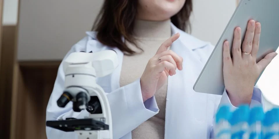 Scientist Using Tablet in Laboratory with Microscope for Research and Analysis Stock Photos