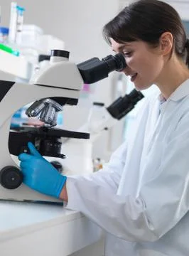 Scientist viewing human tissue sample on microscope in laboratory Stock Photos