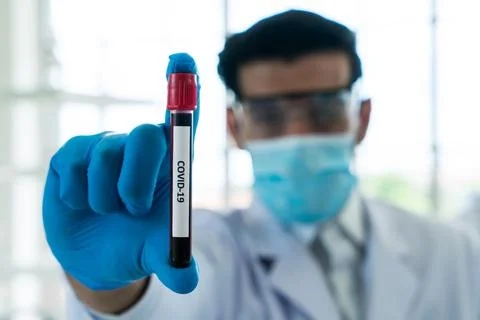 The scientist wears Mask and goggles Carrying Covid 19 blood sample at labora Stock Photos