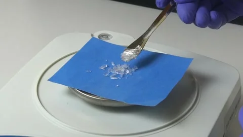 Scientist weighing menthol crystals on precision scale Stock Footage 327977530