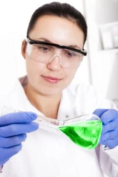 Scientist working in the lab, in protective mask , examines a with liquid Stock Photos