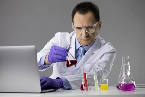 Scientist working at lab with test flasks and computer Stock Photos