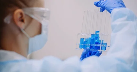 Scientist Working in Laboratory Holdingg Test Tubes and Looking for a Virus Cure Stock-Footage 127595475