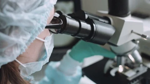 Scientist working in laboratory with microscope Stockbeeldmateriaal 72836964