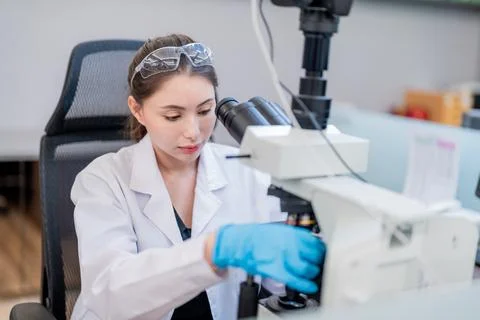 Scientist working in a laboratory using a microscope to analyze samples dur.. Stock Photos