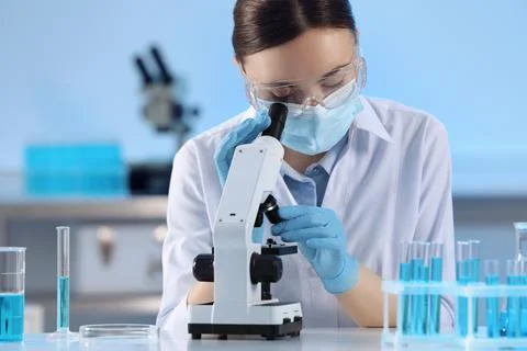 Scientist working with microscope and test tubes in laboratory Stock Photos