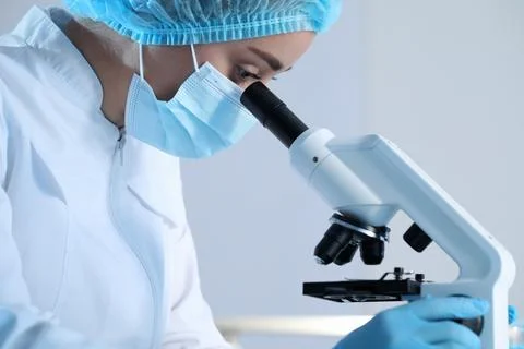 Scientist working with microscope on blurred background, closeup. Medical r.. Stock Photos
