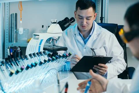 Scientist working with microscope in lab. Laboratory research concept. Stockfoto's