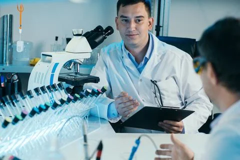 Scientist working with microscope in lab. Laboratory research concept. Stock Photos