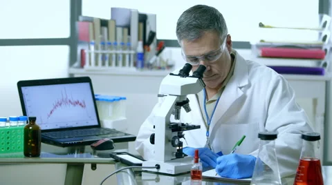 Scientist working with a microscope in laboratory Video stock 58693266